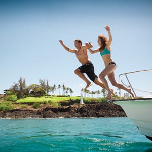 People jumping off a boat into the water